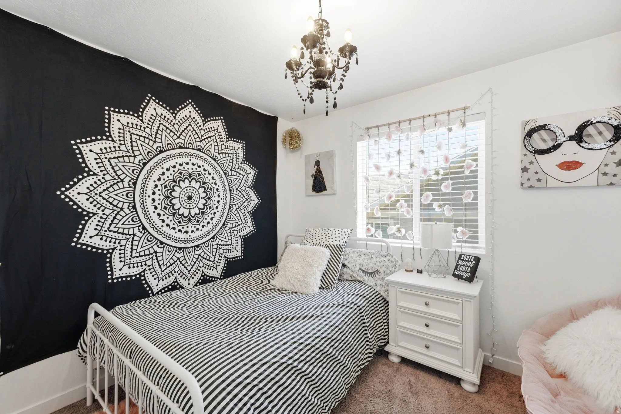 Bright interior space featuring a window with horizontal blinds, a ceiling-mounted chandelier, and light-colored walls