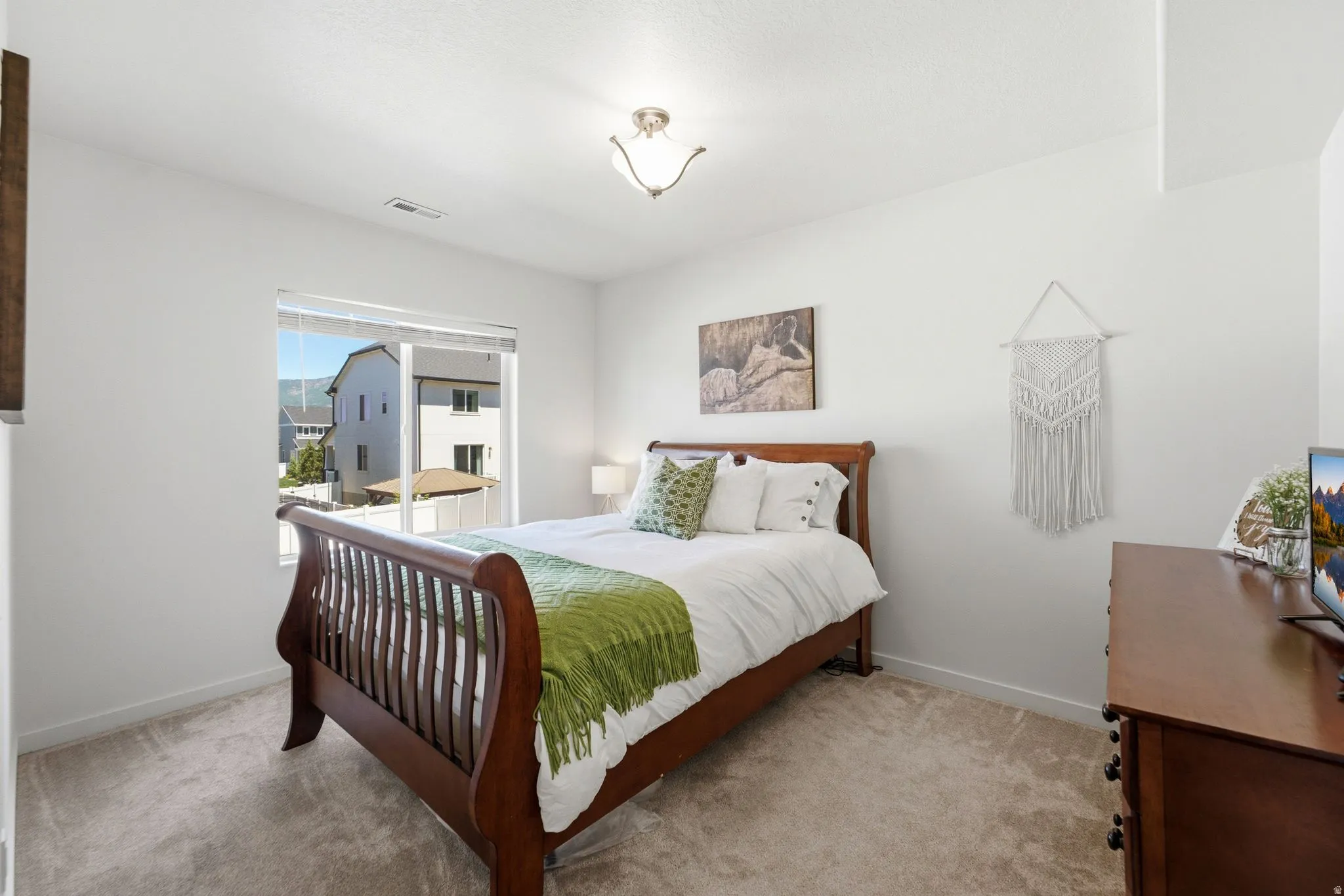 Neutral-toned carpeting extends throughout this interior space, complemented by crisp white walls and a white ceiling