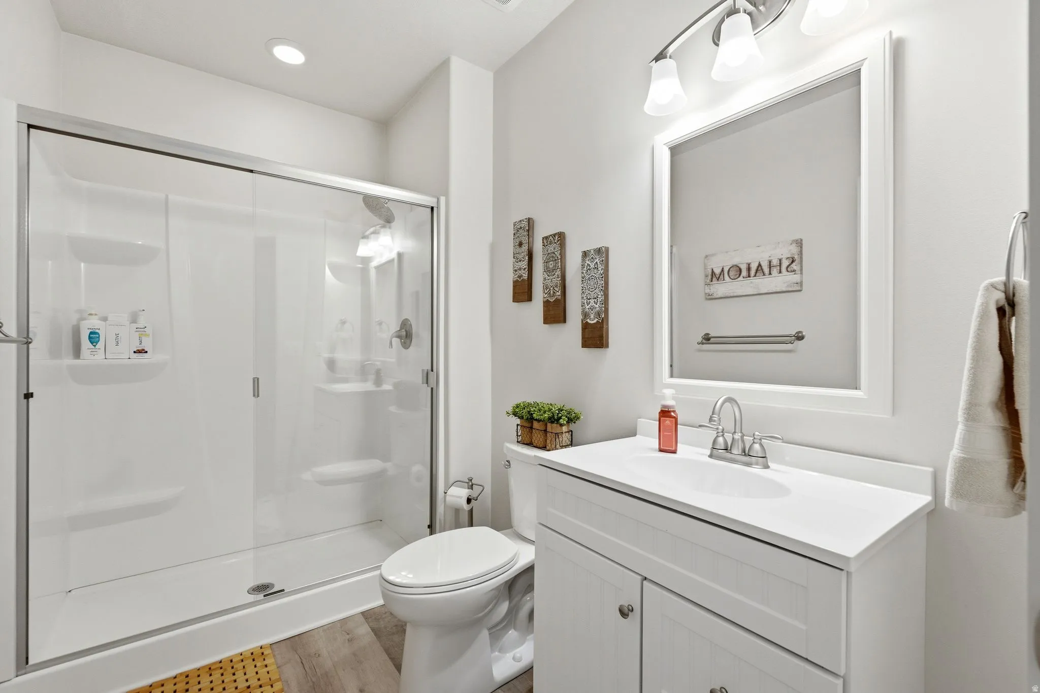 Bathroom featuring a white vanity with integrated sink, faucet, and framed mirror