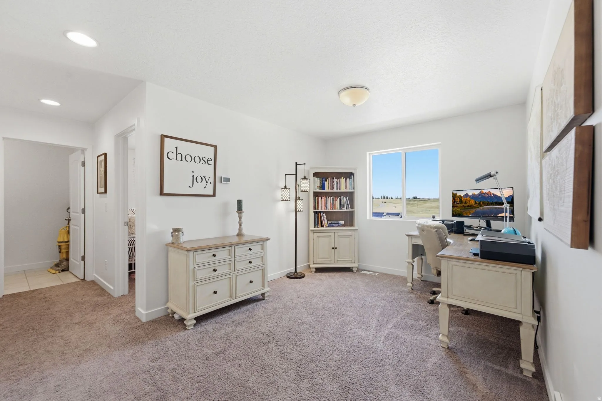 Spacious interior room with light-toned carpeting and white walls