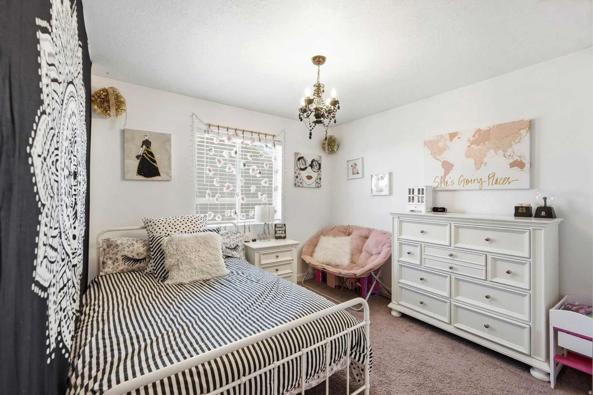 Bedroom featuring a metal bed frame, window with blinds, and white dresser with multiple drawers