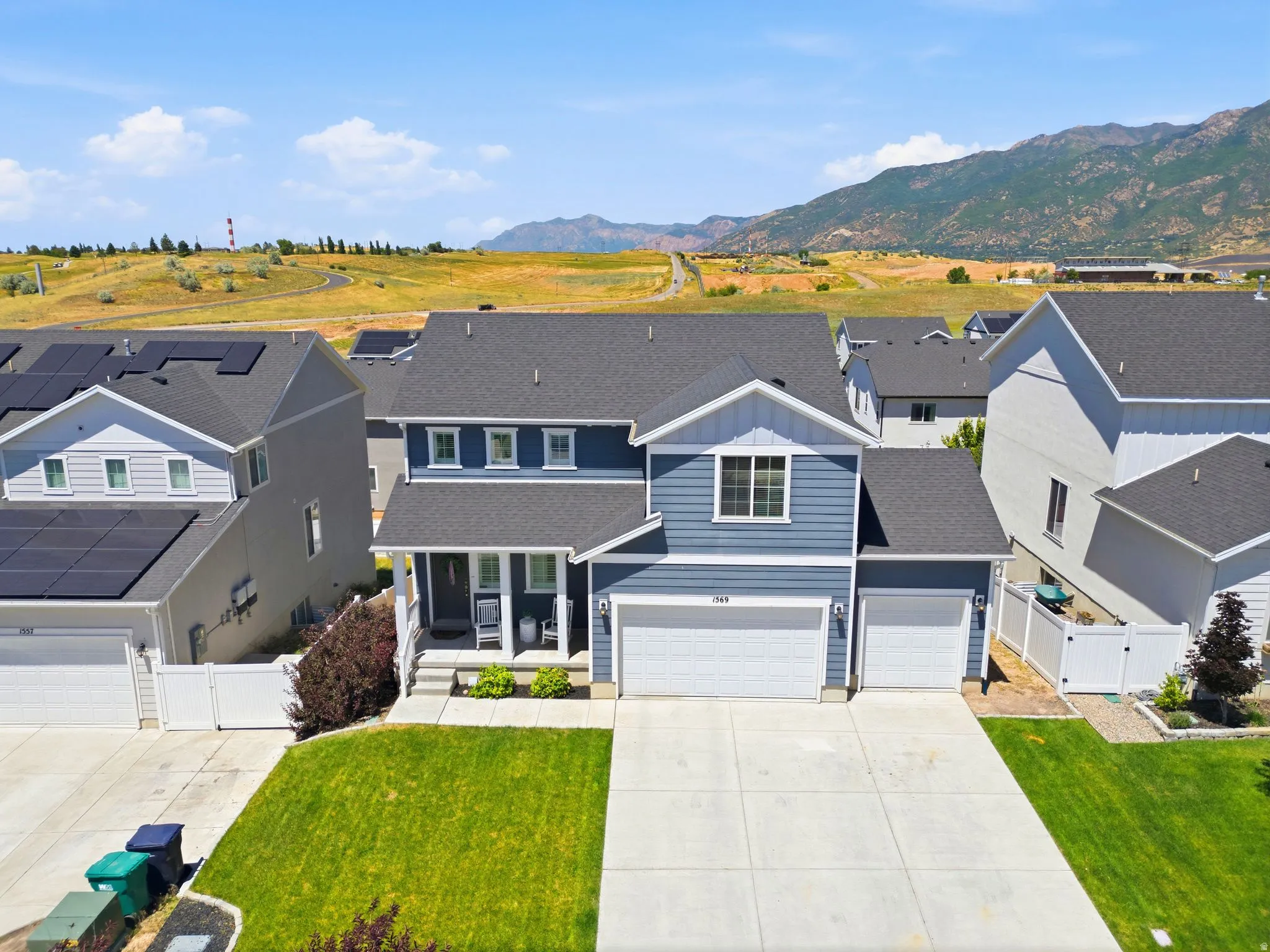 Two-story residence featuring blue siding, white trim accents, a two-car garage, and an additional single-car garage
