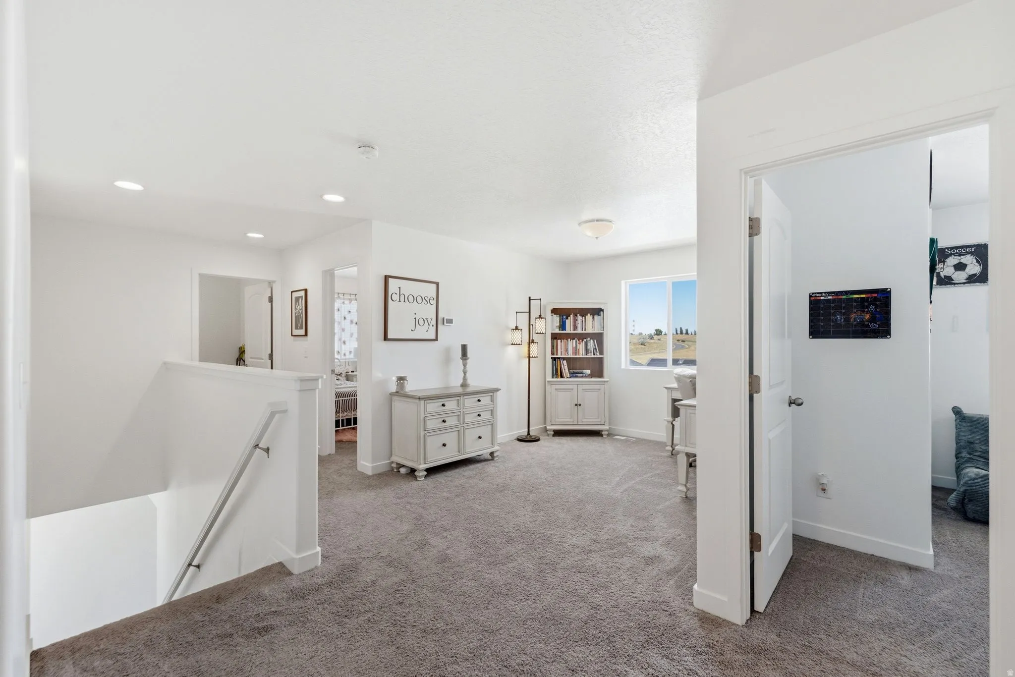Upper level landing featuring carpet flooring and white painted walls