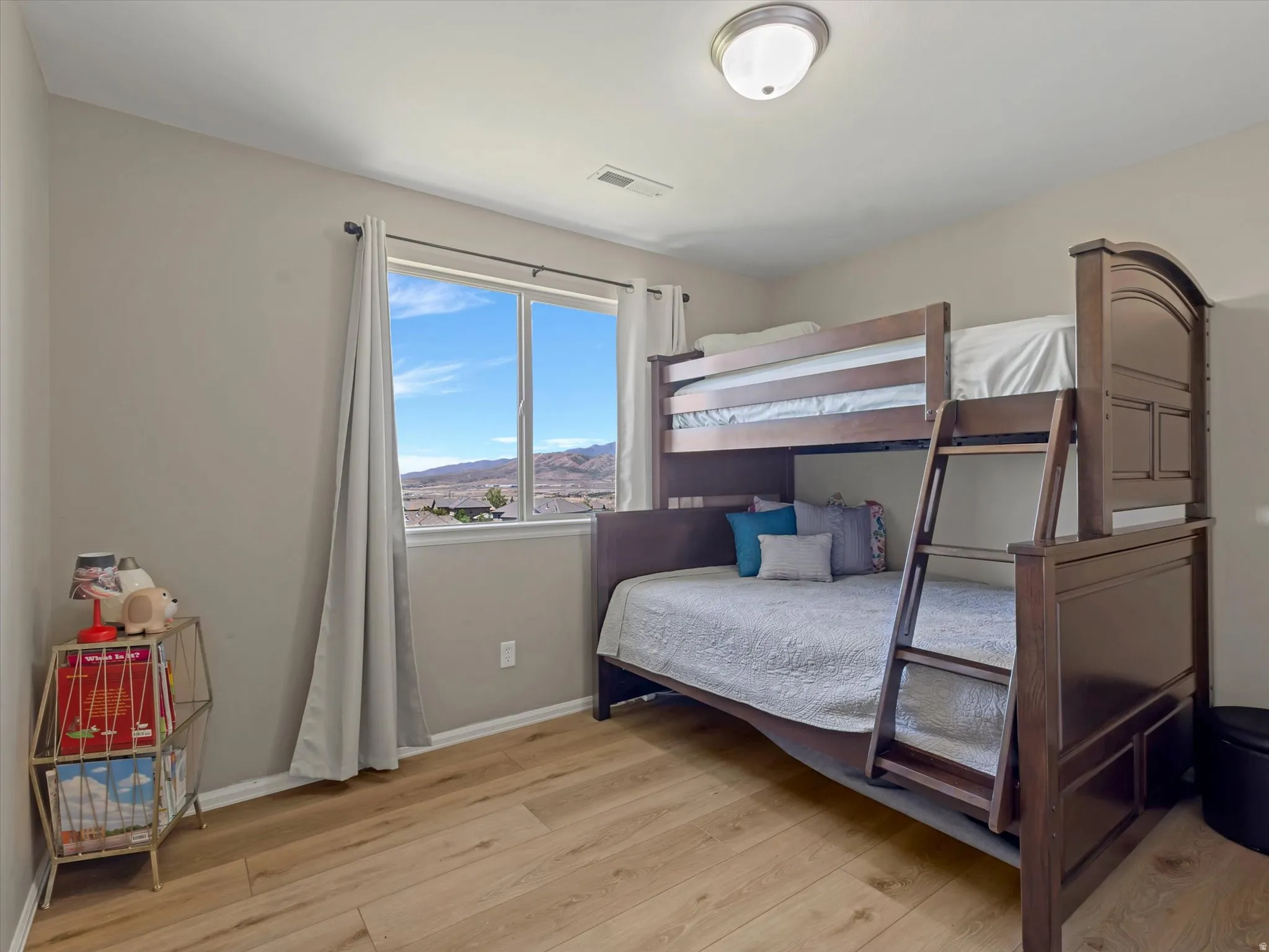 Spacious room featuring wood-finish flooring and a large window
