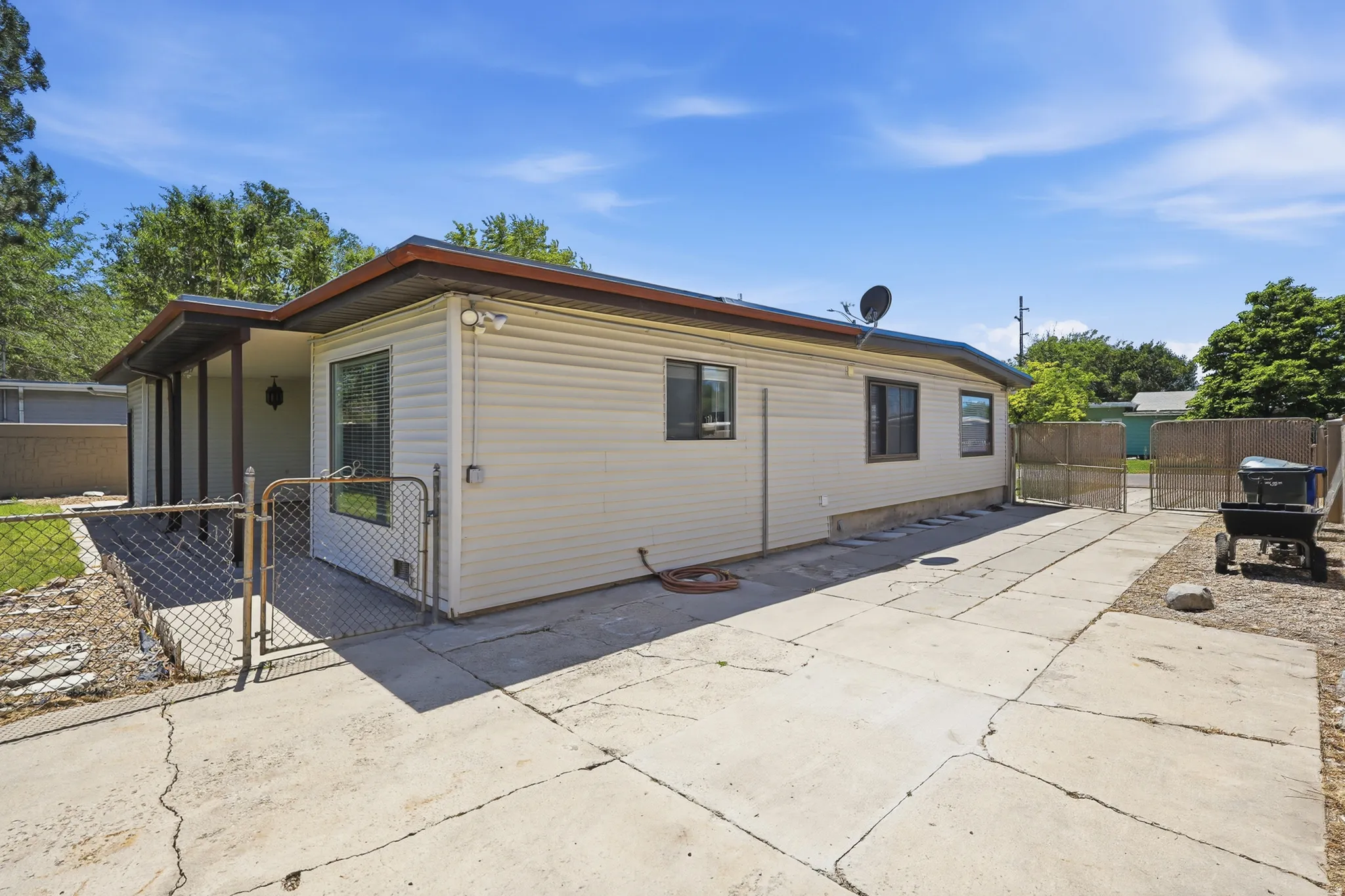 Single-story residence featuring light-colored siding, a covered entry, and multiple windows