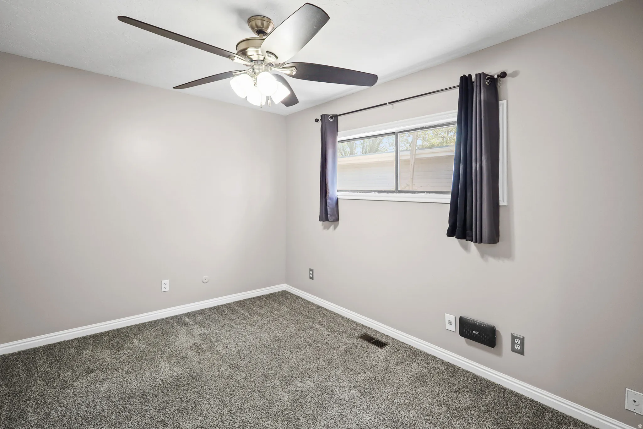 Room with neutral wall paint and gray carpeting