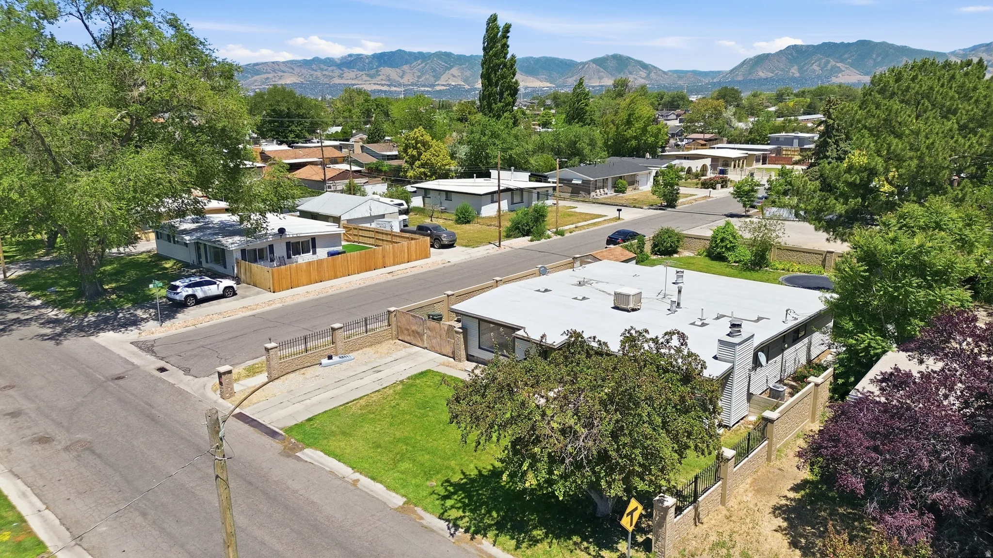 Residential property featuring a gray exterior, a flat roof, and a fenced perimeter