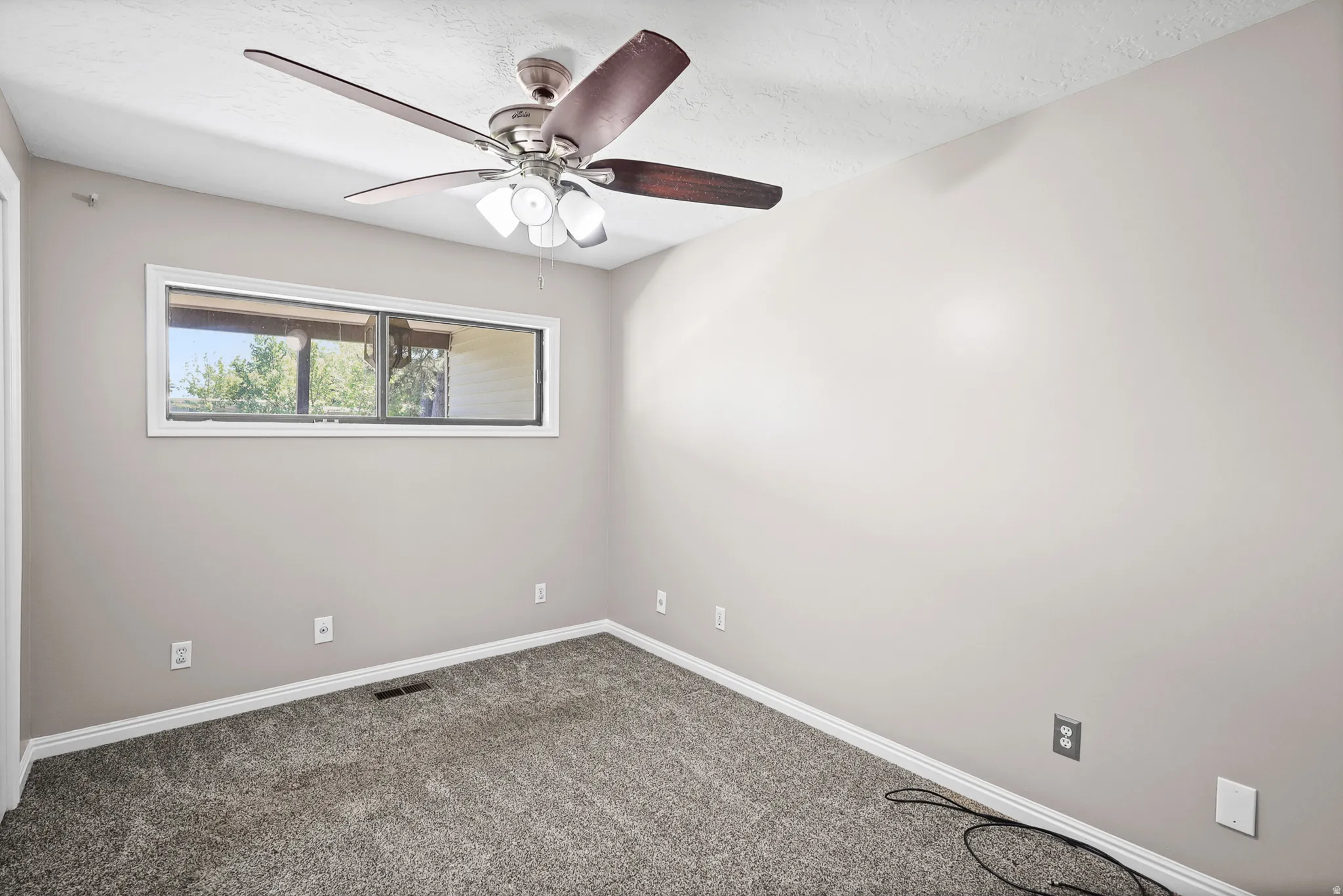 Neutral-toned walls complement plush grey carpeting and white trim