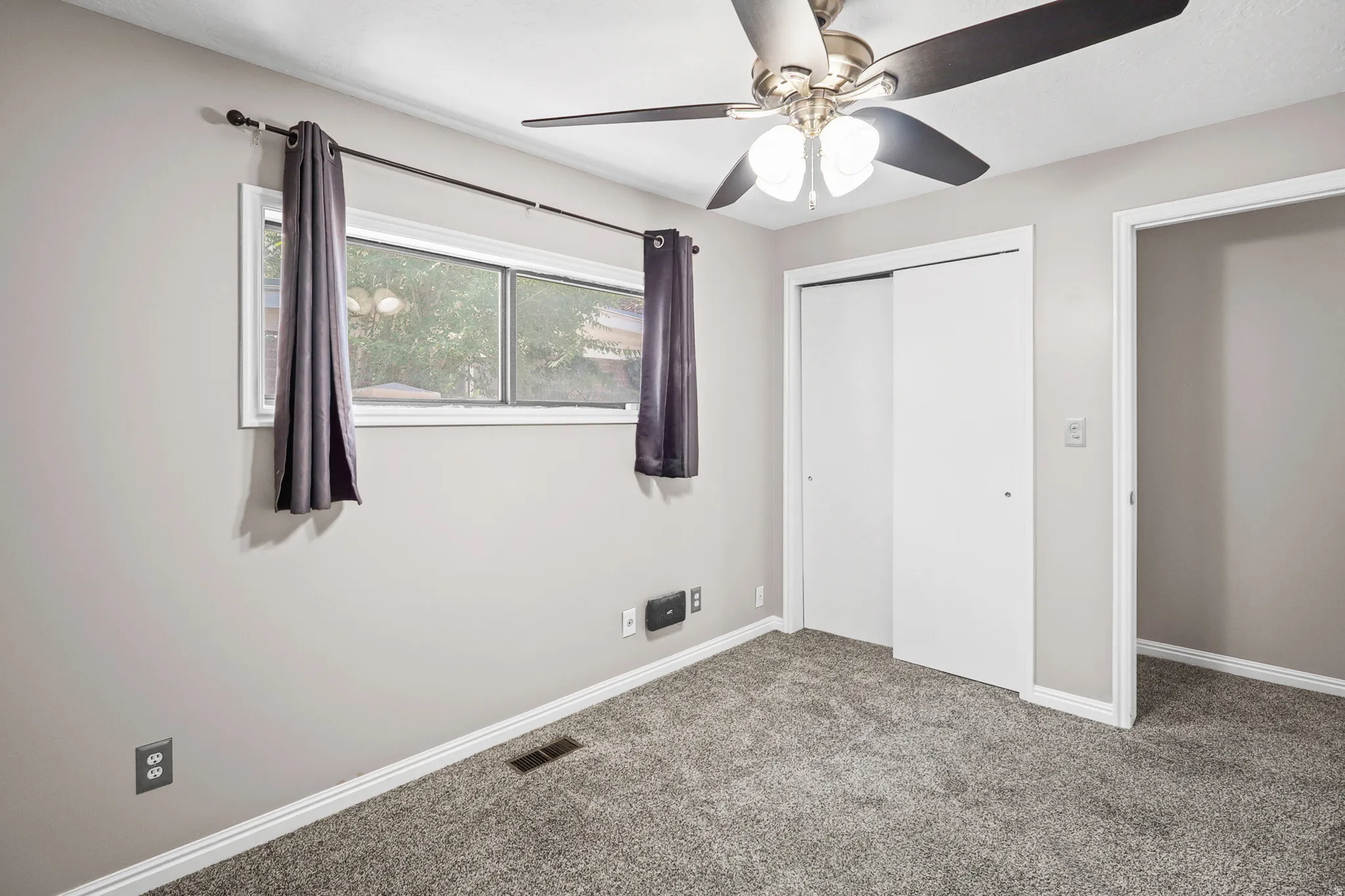 Bedroom featuring light gray wall paint, gray carpeting, and white baseboards