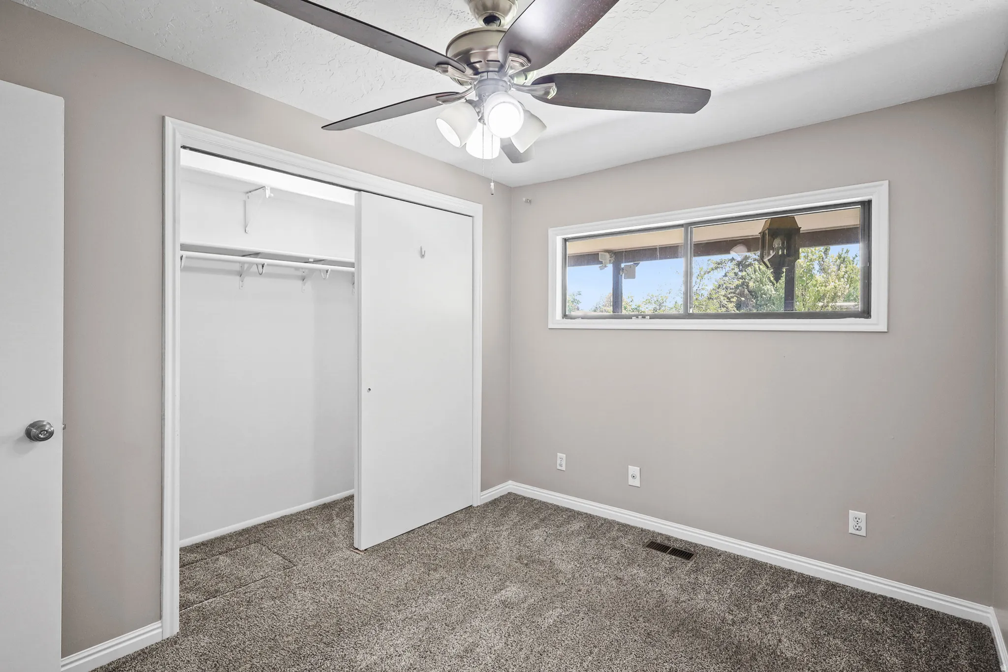 Carpeted room with a horizontal window featuring a white frame