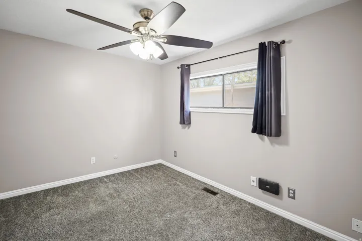 Room with neutral wall paint and gray carpeting