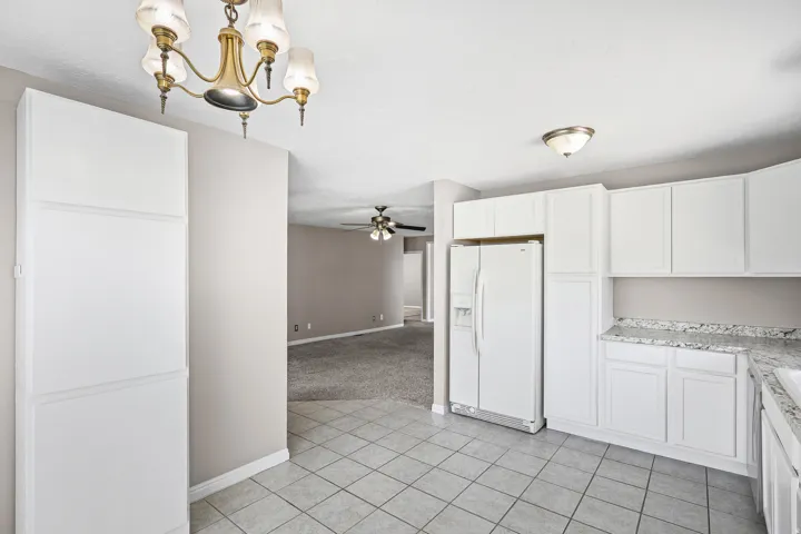 Kitchen featuring white cabinetry, light-toned tiled flooring, and a stone-finish countertop
