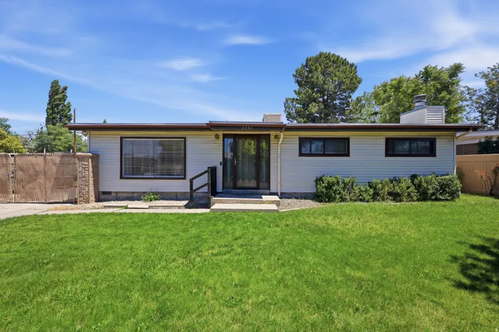 Single-story residence featuring light-colored horizontal siding and a dark trim