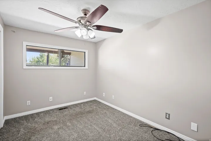 Neutral-toned walls complement plush grey carpeting and white trim