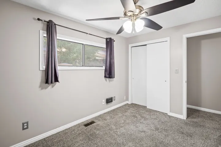 Bedroom featuring light gray wall paint, gray carpeting, and white baseboards