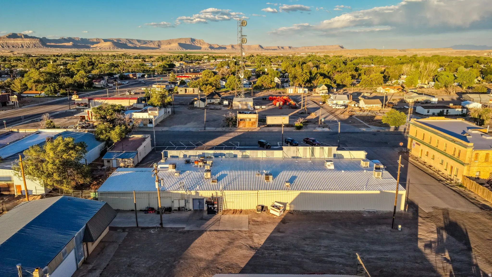 Commercial property featuring a large structure with a metal roof and multiple HVAC units