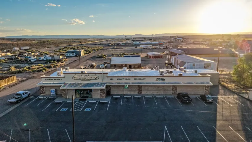 Commercial building featuring a stone and stucco exterior, prominent signage, and a large paved parking lot