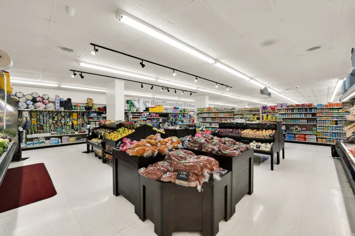 Spacious retail interior featuring white floor tiles and extensive overhead lighting