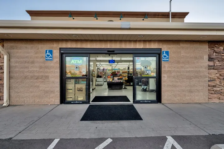 Commercial storefront featuring automatic sliding glass doors and stone veneer accents