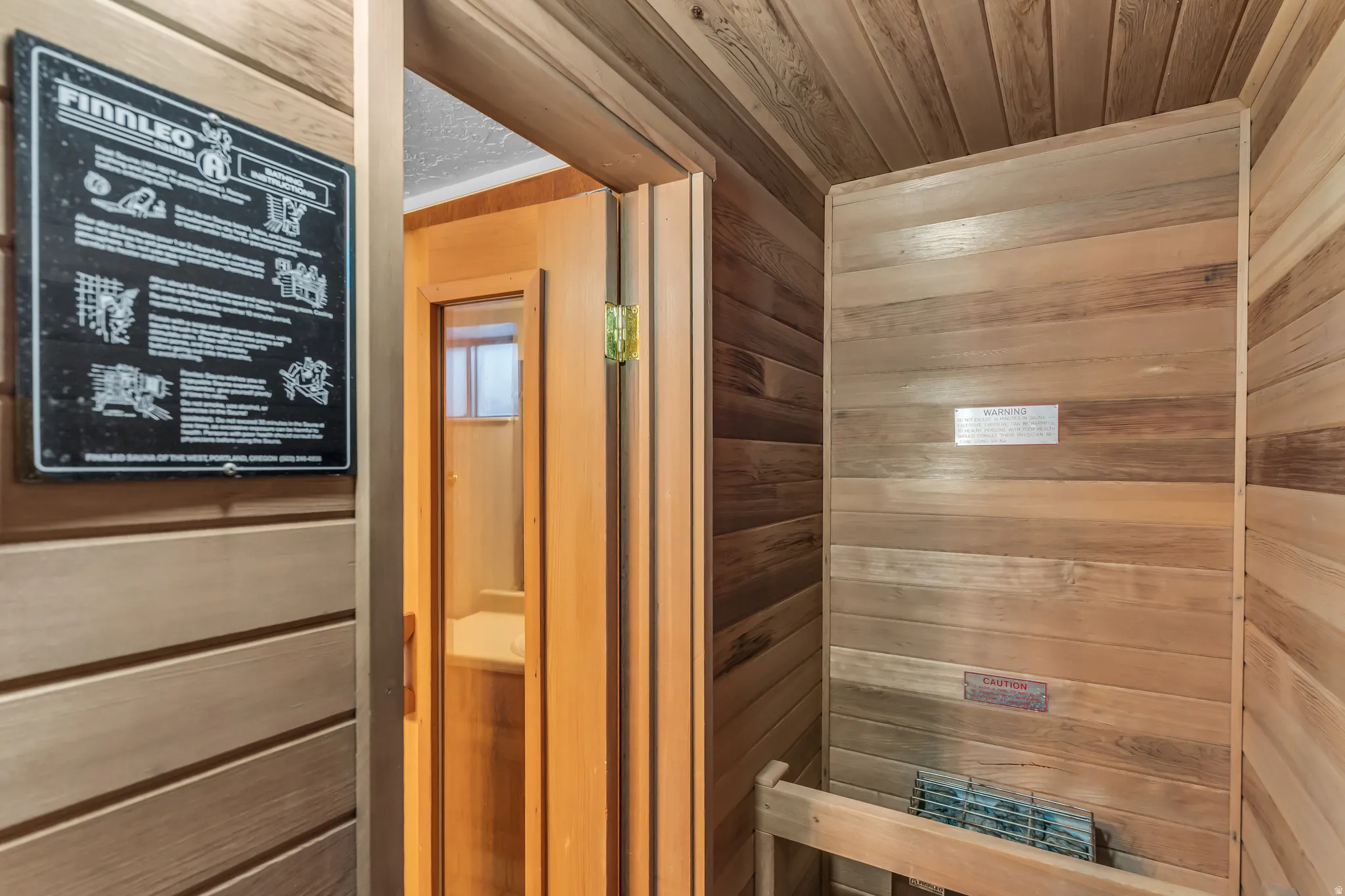 Wood-paneled sauna featuring horizontal wall planks and a built-in heater