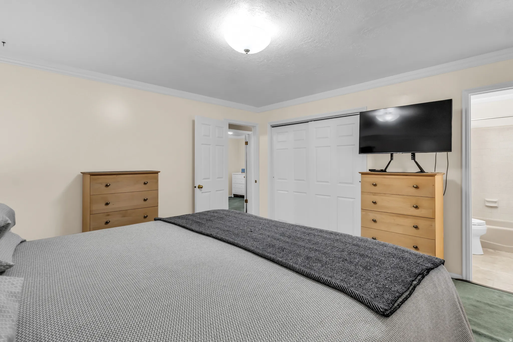 Bedroom featuring light-toned walls, white trim, and a flush-mount ceiling light