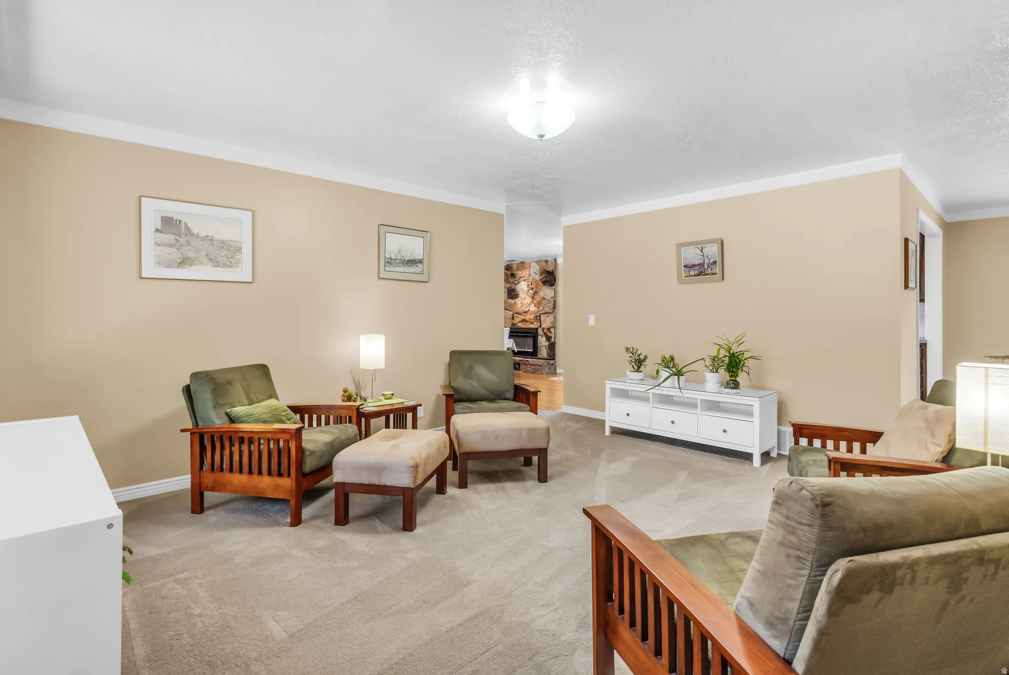 Carpeted living area featuring neutral wall tones and white crown molding