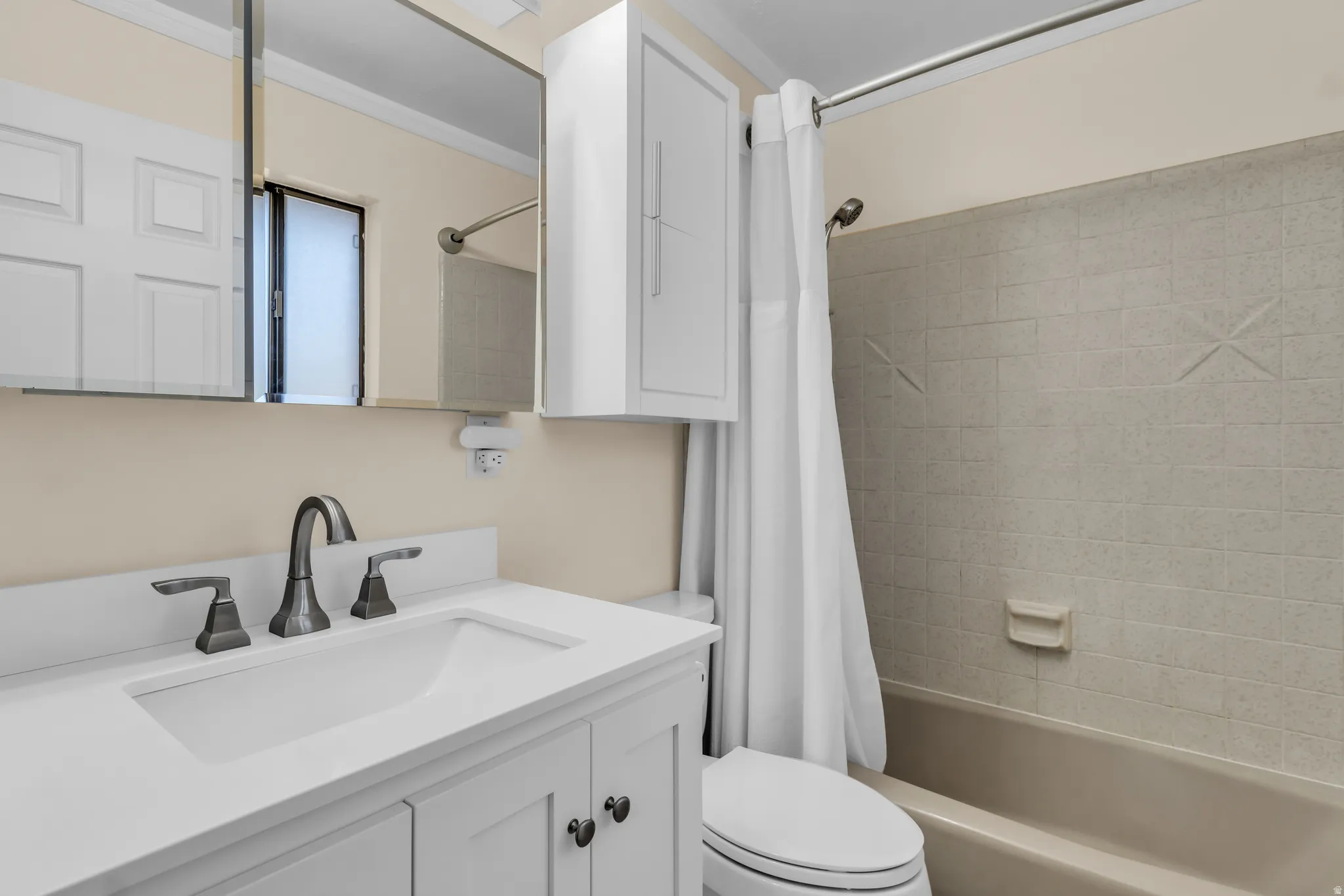 White vanity with integrated sink, three-piece dark-finish faucet, and coordinating dark-finish cabinet hardware