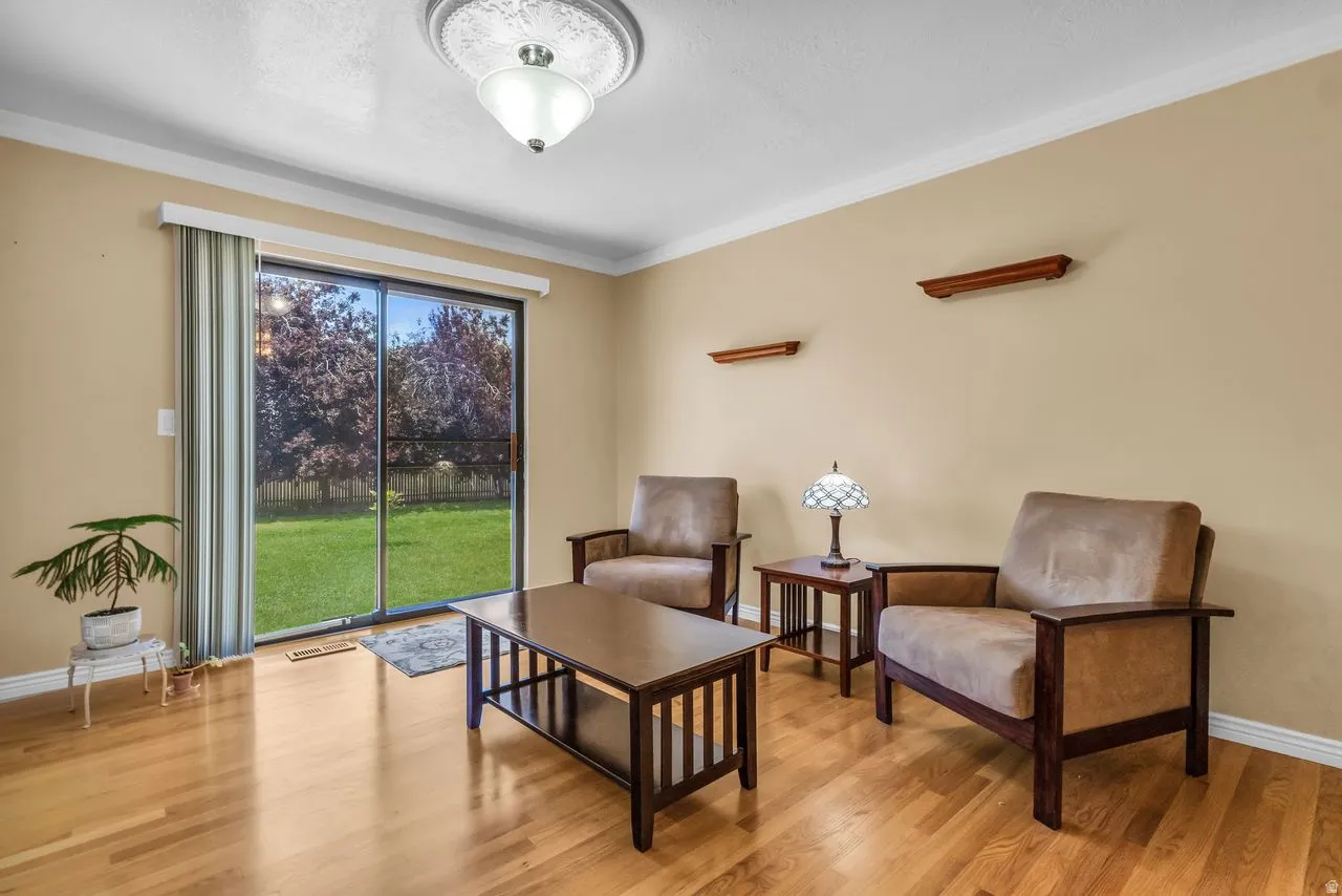 Interior space featuring wood-finish flooring, light-colored walls, and white crown molding