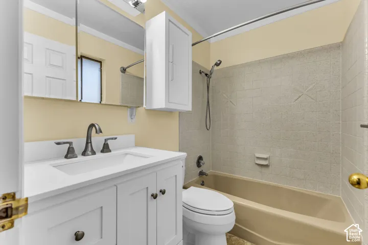 White vanity with integrated sink, dark bronze-finish faucet, recessed medicine cabinet, and built-in shower/tub combination