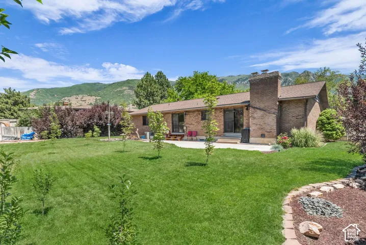 Expansive green lawn with mature landscaping and a brick-built chimney