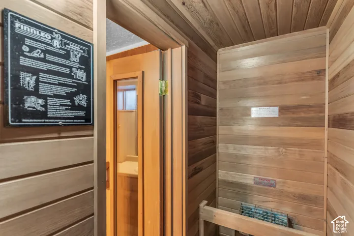 Wood-paneled sauna featuring horizontal wall planks and a built-in heater
