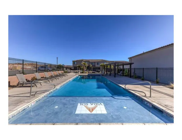 Expansive outdoor pool with integrated shallow area featuring a decorative tile inlay