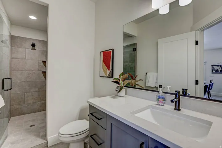 Bathroom featuring a walk-in shower with tiled walls and flooring, a glass enclosure, and a built-in shelf