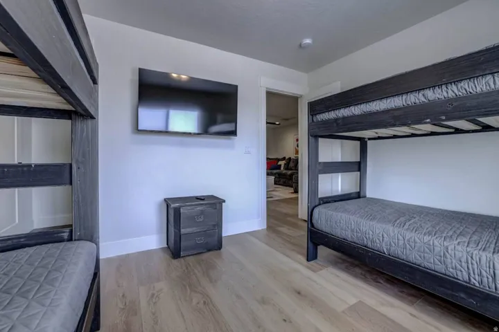 Bedroom featuring wood-finish flooring, white baseboards, and light-toned walls