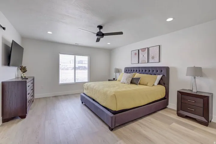 Spacious room featuring light wood-finish flooring and a contemporary black ceiling fan