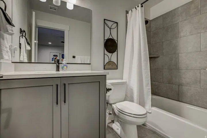 Contemporary bathroom featuring a single vanity with a light gray cabinet base, a light-colored countertop, and a rectangular sink