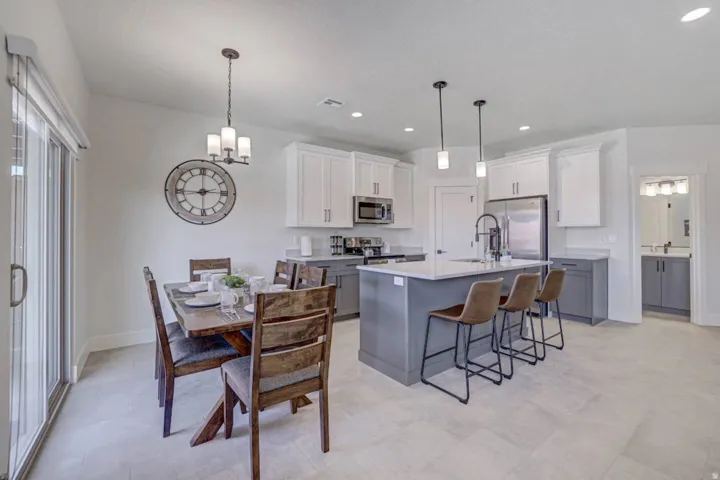 Contemporary kitchen and dining area featuring light-toned tile flooring throughout