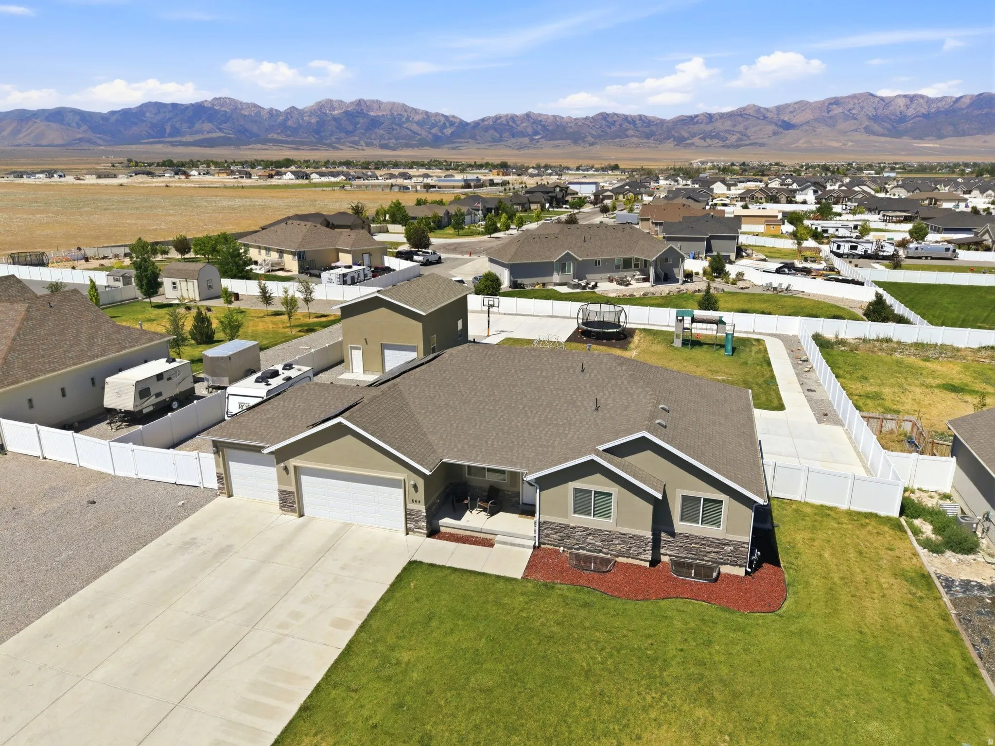 Ranch-style residence featuring a two-car garage, stone veneer accents, and a covered porch