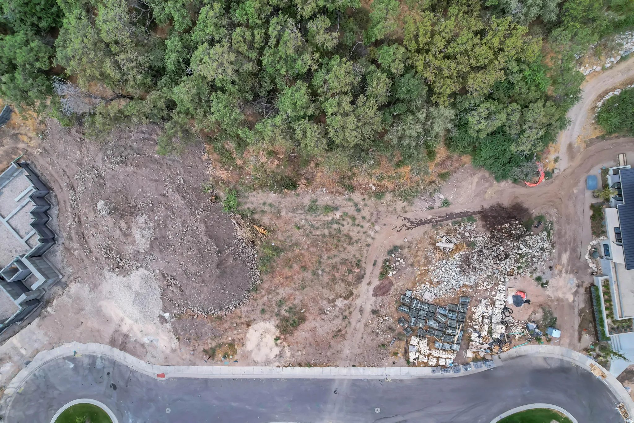 Cleared lot featuring a paved cul-de-sac frontage and bordering mature trees