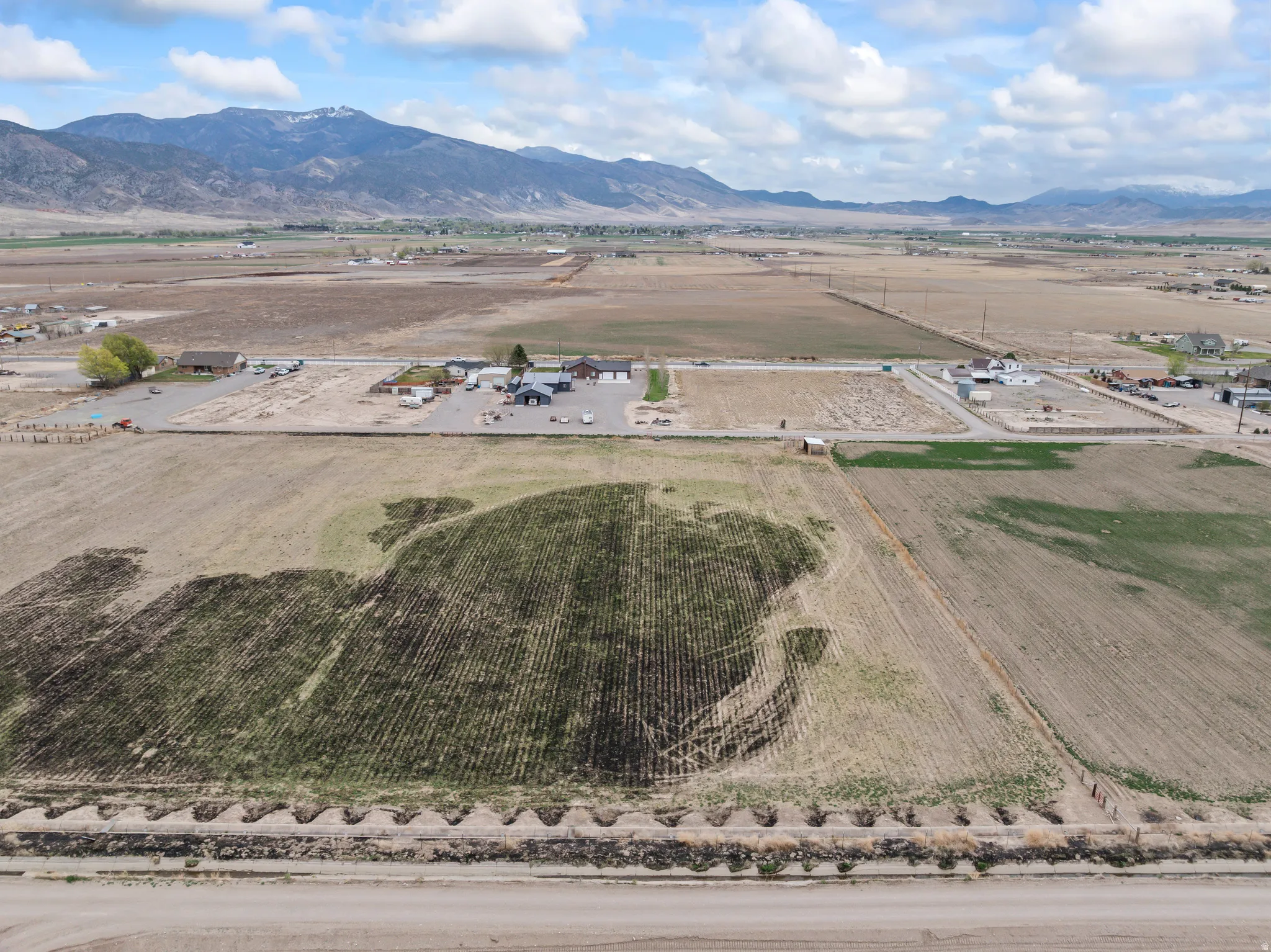 Expansive agricultural land with distinct cultivated sections and perimeter fencing