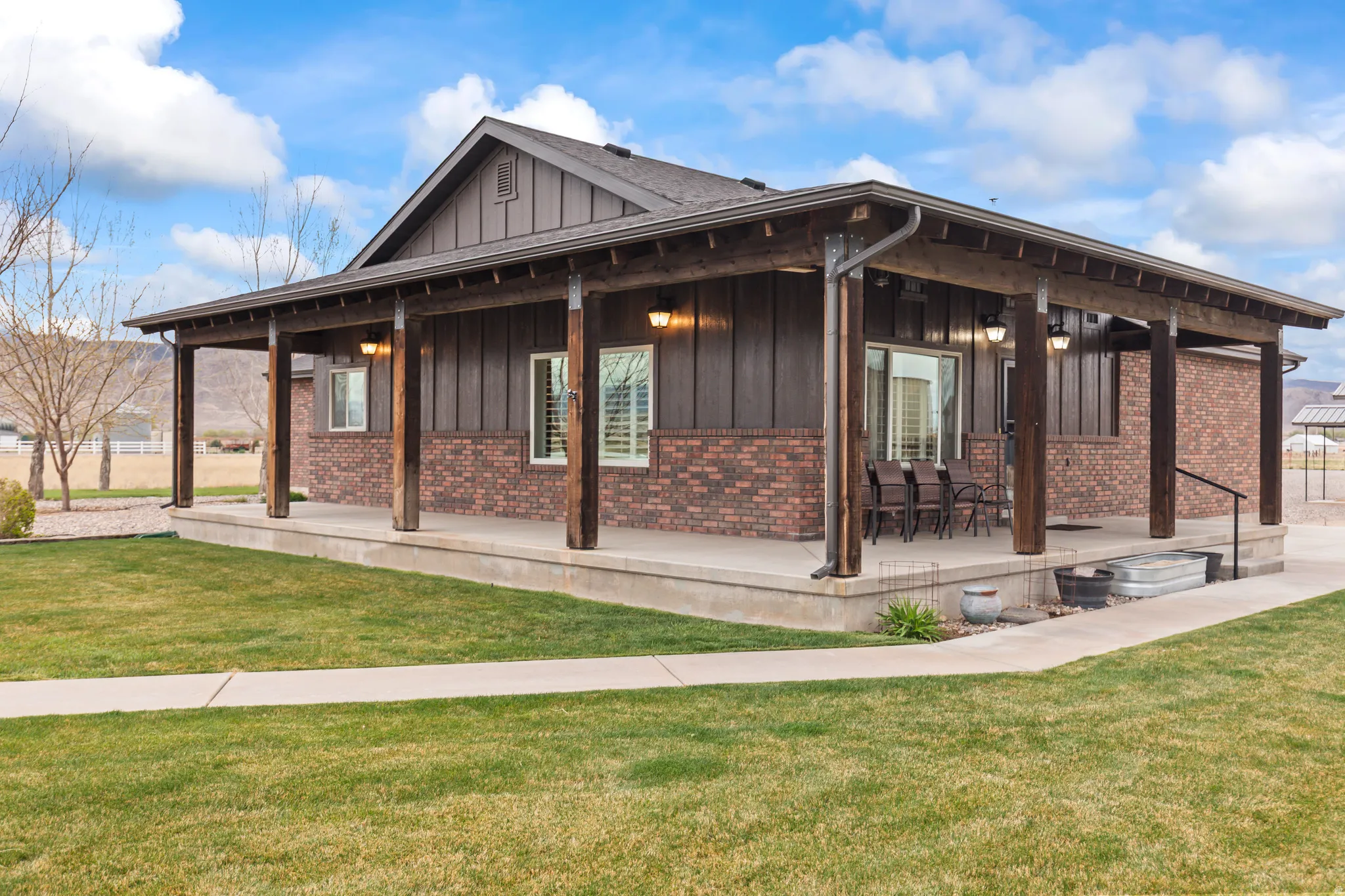 Spacious covered porch with exposed wood beams and recessed lighting