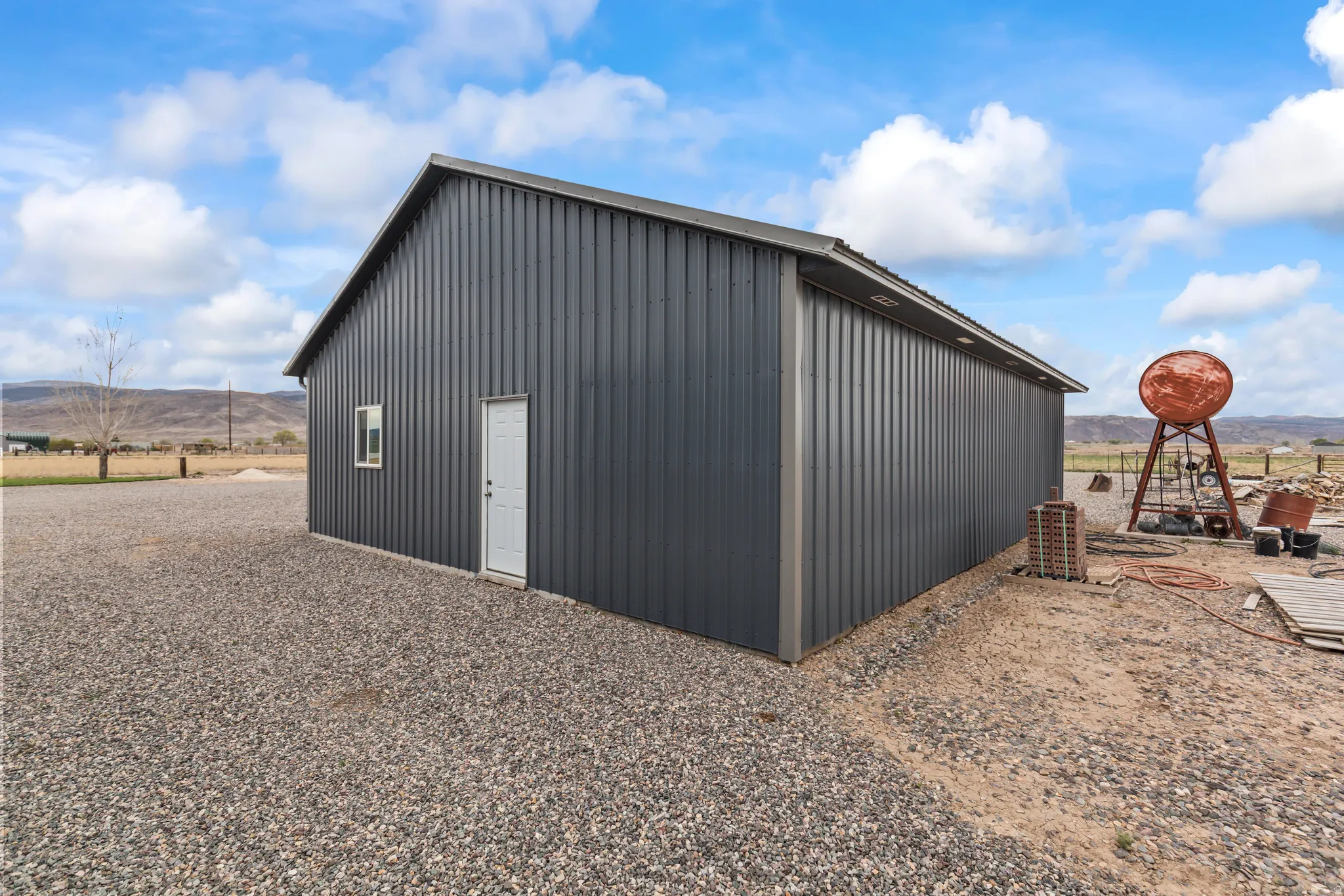 Freestanding metal-sided outbuilding with a single entry door and an individual window