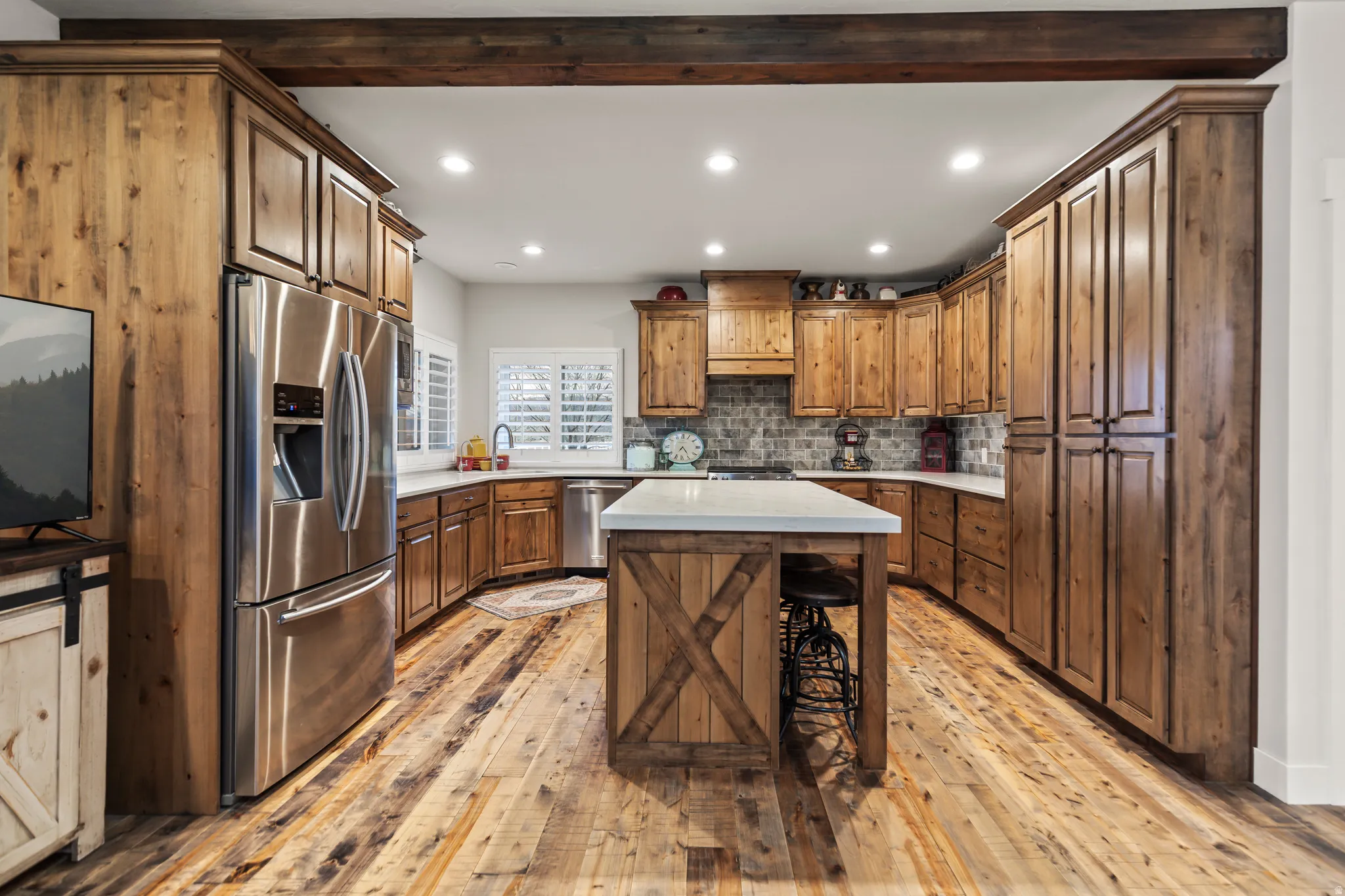 Kitchen featuring wood-finish flooring, custom wood cabinetry, and a central island with a white countertop