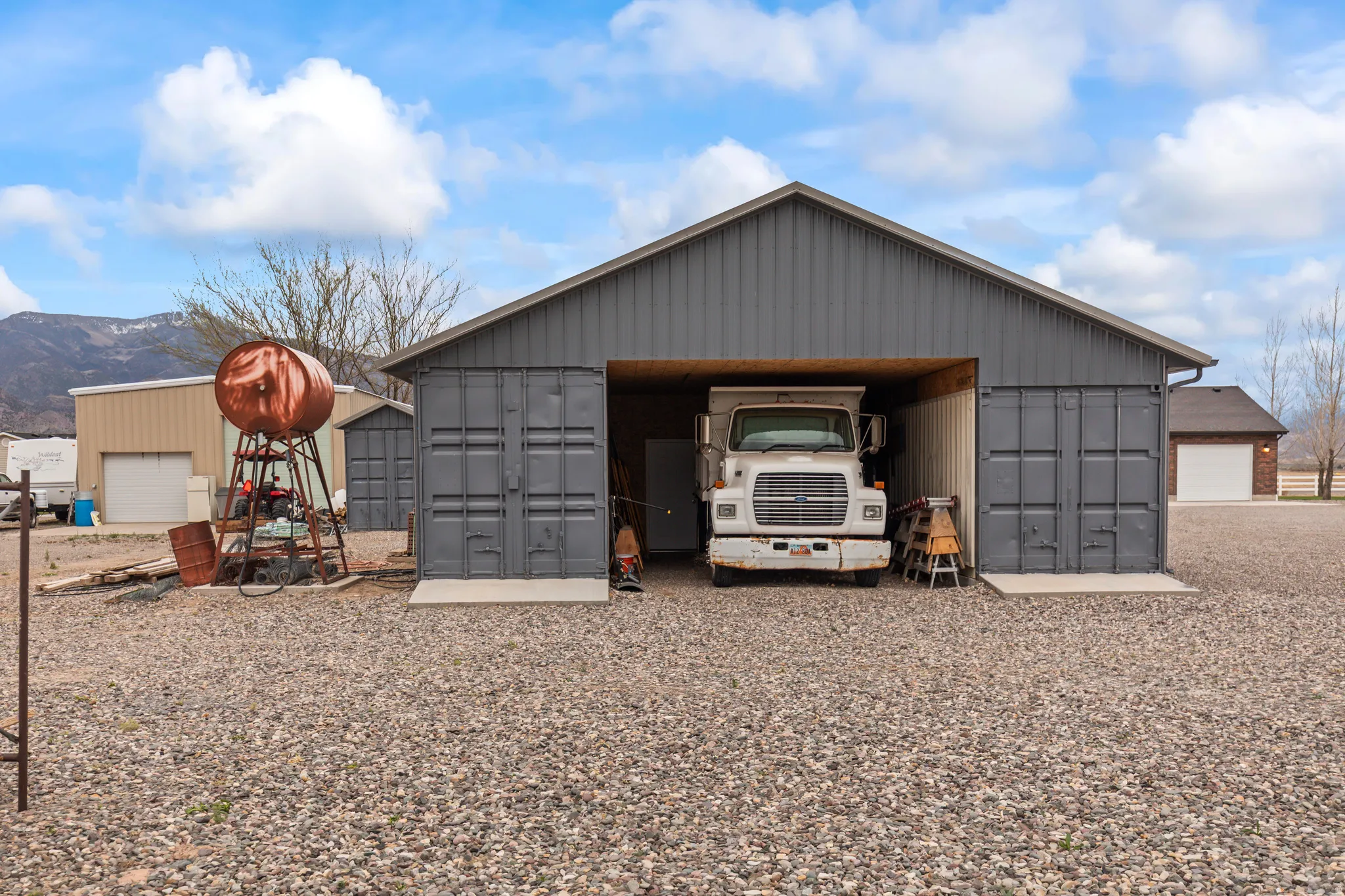 Metal-sided outbuilding with a large open bay and container-style doors