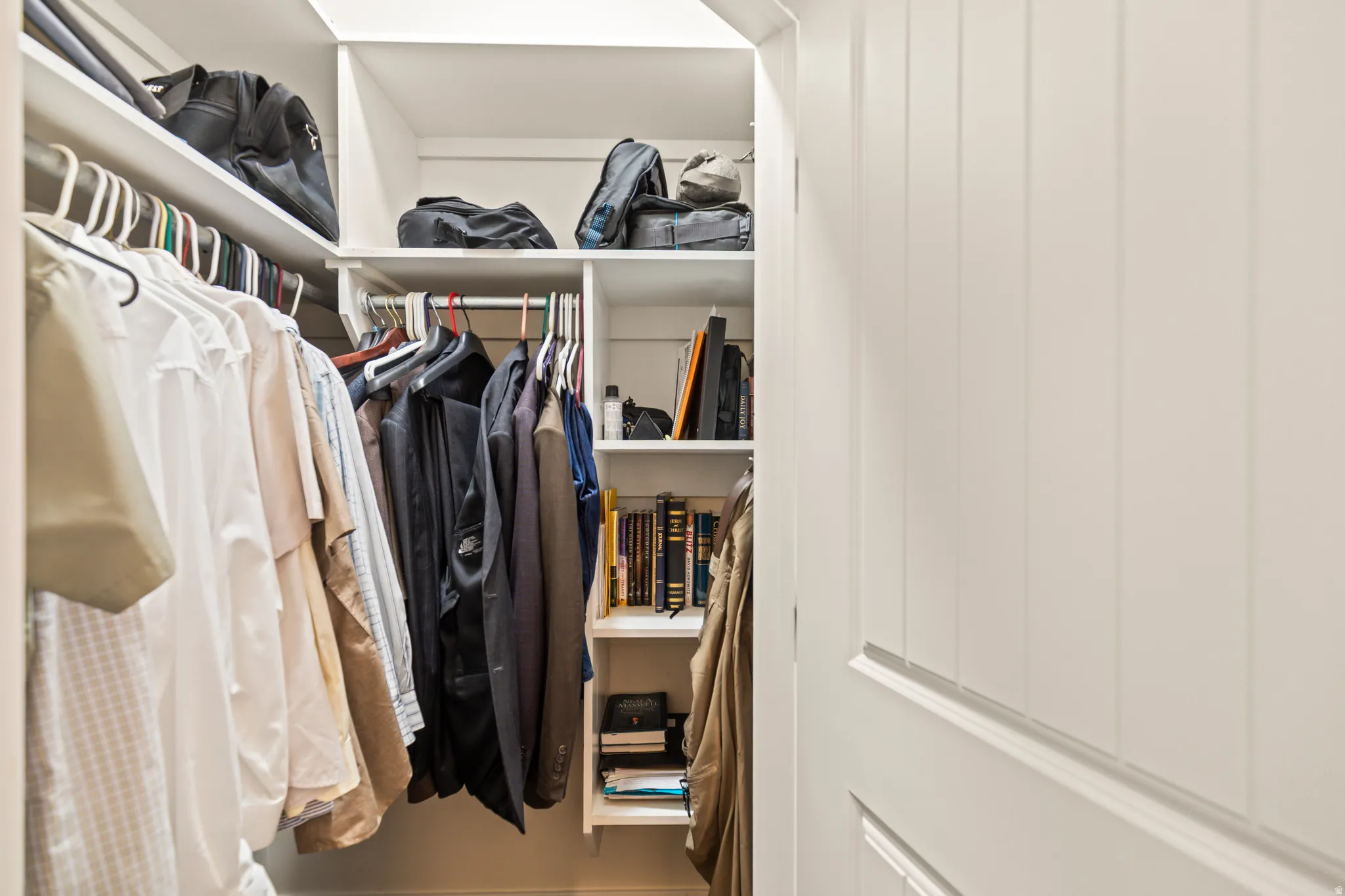 Custom closet system featuring multiple hanging rods, integrated shelving, and white finishes