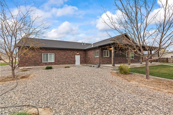 Brick exterior with a dark shingle roof and a covered porch featuring wood posts