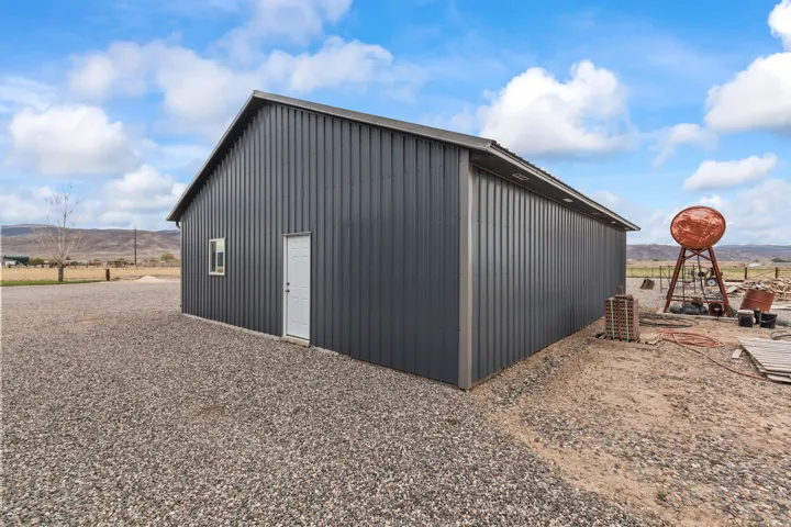 Freestanding metal-sided outbuilding with a single entry door and an individual window