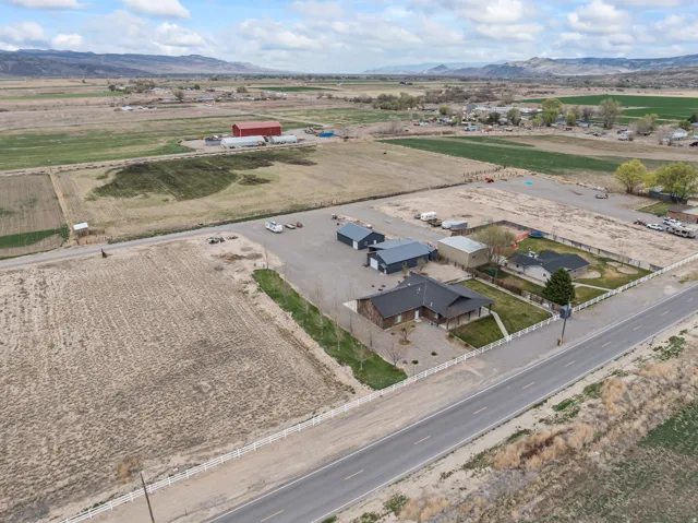 Expansive property featuring a modern ranch-style home, multiple outbuildings, and extensive gravel parking areas
