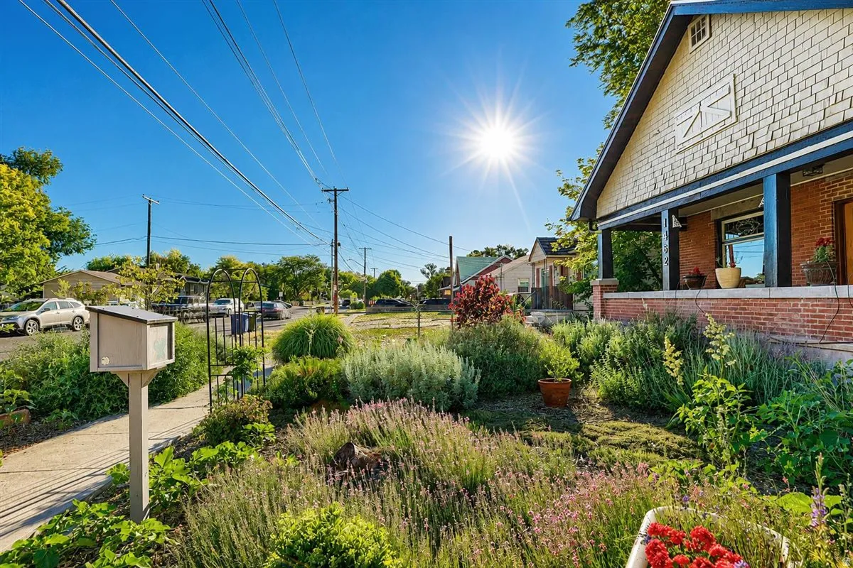 Front exterior featuring a covered porch with brick detailing and shake siding