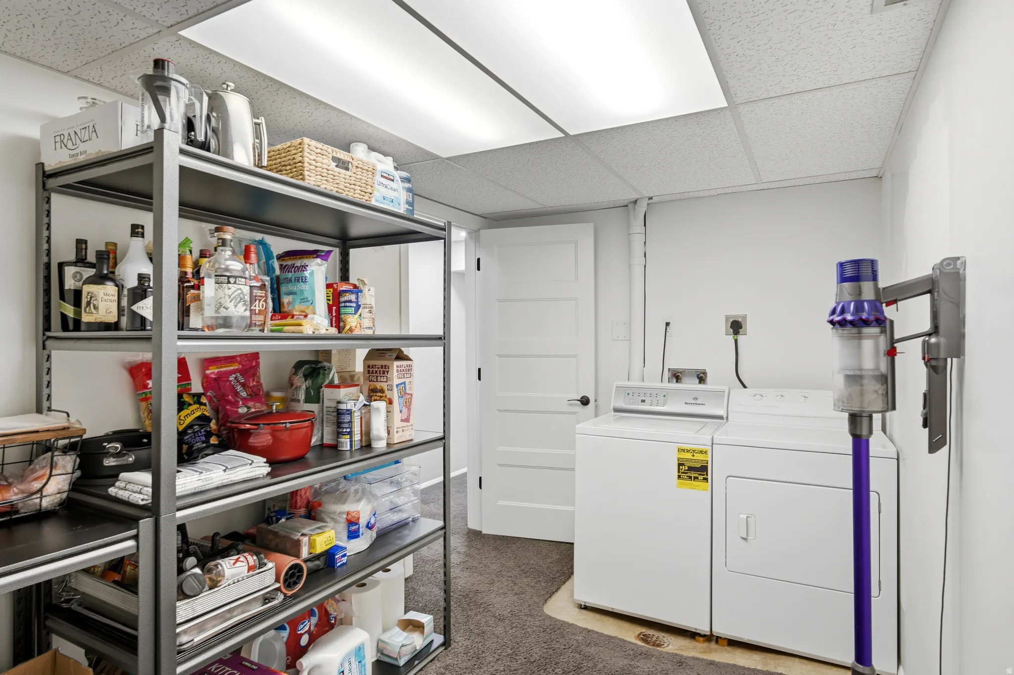 Laundry area featuring a side-by-side washer and dryer, white paneled door, and drop ceiling with recessed lighting
